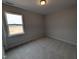 A well-lit bedroom with neutral carpet, large window offering natural light and a closet for storage at 46 Steppe Way, Garner, NC 27529