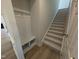 Hallway with coat rack and bench, wooden flooring, and a carpeted staircase leading upstairs at 46 Steppe Way, Garner, NC 27529