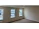 Well-lit bedroom with three windows and carpet at 4937 S Trout Crest, Raleigh, NC 27604
