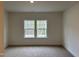 Well-lit bedroom with neutral carpet and two windows at 4937 S Trout Crest, Raleigh, NC 27604