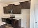 Modern kitchen with dark brown cabinets and quartz countertops at 4937 S Trout Crest, Raleigh, NC 27604