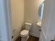 Clean powder room with a toilet, sink, and circular mirror at 4937 S Trout Crest, Raleigh, NC 27604