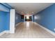 Basement with tile flooring, blue walls, and a partial kitchen area visible in the distance at 501 Queensferry Rd, Cary, NC 27511