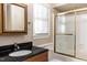 Traditional-style bathroom featuring a black granite countertop, gold-framed mirror, and shower with gold trim at 501 Queensferry Rd, Cary, NC 27511