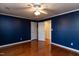Bedroom showcasing hardwood floors, ceiling fan, closet doors, and an open doorway at 501 Queensferry Rd, Cary, NC 27511