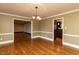 Inviting dining room featuring beautiful hardwood floors, wainscoting, and a stylish chandelier at 501 Queensferry Rd, Cary, NC 27511
