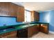 Traditional kitchen featuring wooden cabinetry, a double sink, and green countertops at 501 Queensferry Rd, Cary, NC 27511