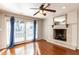 Cozy living room featuring a fireplace, hardwood floors, and sliding glass doors with blue curtains at 501 Queensferry Rd, Cary, NC 27511