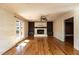 Living room with hardwood floors, fireplace, built-in shelving, and a ceiling fan at 501 Queensferry Rd, Cary, NC 27511