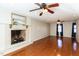 Spacious living room with hardwood floors, a ceiling fan, and a fireplace, perfect for entertaining guests at 501 Queensferry Rd, Cary, NC 27511