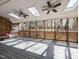 Spacious sunroom with skylights, ceiling fans, and screened windows overlooking a wooded backyard at 501 Queensferry Rd, Cary, NC 27511