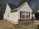 Side view of the house showcasing vinyl siding and a brick base at 6020 Newhall Rd, Durham, NC 27713