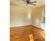 Hardwood floor living room with large window and ceiling fan at 648 Linfield Dr, Durham, NC 27701