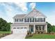 Two-story house with gray siding, white trim, and a teal front door at 8829 Tartan Clan Dr, Willow Springs, NC 27592