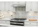 Modern kitchen with gas cooktop and white cabinets at 8829 Tartan Clan Dr, Willow Springs, NC 27592