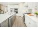 Modern kitchen with white cabinets, stainless steel appliances and an island at 8829 Tartan Clan Dr, Willow Springs, NC 27592