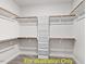 Walk-in closet featuring custom shelving, wooden rods, and carpeted floor, maximizing storage and organization at 116 Mohave Dr, Louisburg, NC 27549