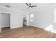 Bright room with window, hardwood floors, open entrance to bathroom, and modern ceiling fan at 1246 Jamestowne Dr, Elon, NC 27244