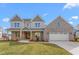 Beautiful two-story home with brick accents, a well-manicured lawn, and a two-car attached garage at 1246 Jamestowne Dr, Elon, NC 27244
