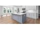 Bright kitchen boasts an island with a sink, white cabinets, and stainless steel appliances at 1246 Jamestowne Dr, Elon, NC 27244