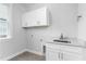 Well-lit laundry room with white cabinets and granite countertops at 1246 Jamestowne Dr, Elon, NC 27244