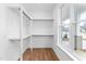 Bright walk-in closet with shelving and rod system, wood floor, and a window for natural light at 1246 Jamestowne Dr, Elon, NC 27244