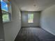 A well-lit bedroom featuring gray carpet, white walls, and two windows at 136 Parker Ln, Mebane, NC 27302