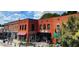 Two-story brick building with various businesses, outdoor seating, and lush trees at 201 Broomgrove Way, Wake Forest, NC 27587
