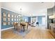 Open-concept dining room with modern chandelier, gallery wall, and view into the living area at 201 Broomgrove Way, Wake Forest, NC 27587