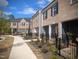 New townhomes show brick and siding exteriors with black shutters and fenced front yard spaces at 201 Broomgrove Way, Wake Forest, NC 27587