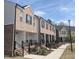 Newly constructed townhomes with brick exteriors and black shutters, with sidewalks and landscaping at 201 Broomgrove Way, Wake Forest, NC 27587