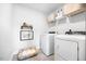 Well-lit laundry room features a washer, dryer, shelving, and a pet bed for convenience at 201 Broomgrove Way, Wake Forest, NC 27587