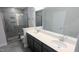 Modern bathroom featuring double sinks, quartz countertops, and a tiled walk-in shower at 205 Broomgrove Way, Wake Forest, NC 27587
