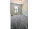 Carpeted bedroom is bright, featuring a window view of the neighborhood at 205 Broomgrove Way, Wake Forest, NC 27587