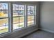 Bedroom featuring three large windows with a view of a new construction neighborhood at 205 Broomgrove Way, Wake Forest, NC 27587