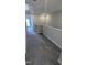 Well-lit hallway features neutral paint, plush gray carpeting, and white railing at 205 Broomgrove Way, Wake Forest, NC 27587