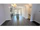 Open-concept living space featuring hardwood floors, a modern chandelier, and kitchen view at 205 Broomgrove Way, Wake Forest, NC 27587