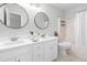 Bathroom with double vanity, white cabinets, and a large mirror at 210 Charlotte Ct, Clayton, NC 27520