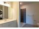 Modern bathroom with white vanity, gray tile shower, and washer/dryer in the background at 2426 Gathering Square Ct # 2426, Fuquay Varina, NC 27526