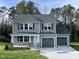 Two-story house with gray siding, two-car garage, and a stone facade at 309 Starry Sky Dr, Benson, NC 27504