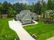 Aerial view showcasing a home with a large driveway, lush lawn, surrounded by dense trees at 3913 Cedar Knolls # 7, Youngsville, NC 27596