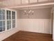Elegant dining area boasts wainscoting, modern chandelier, and a large window at 3913 Cedar Knolls # 7, Youngsville, NC 27596