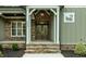 Close-up of a front door with stone accents, elegant lighting, and a landscaped entryway at 3913 Cedar Knolls # 7, Youngsville, NC 27596