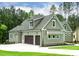 Exterior view of a three car garage with dark wooden doors, set on a sprawling green lawn at 3913 Cedar Knolls # 7, Youngsville, NC 27596