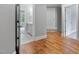 Hallway leading to a bathroom with gray vanity and white tile, featuring beautiful hardwood floors at 3913 Cedar Knolls # 7, Youngsville, NC 27596