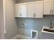 Bright laundry room features ample cabinet space, modern sink, and convenient utility connections at 3913 Cedar Knolls # 7, Youngsville, NC 27596