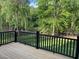 Outdoor patio featuring a wood floor with black railings and a tranquil view of the lush, green surroundings at 3913 Cedar Knolls # 7, Youngsville, NC 27596