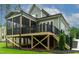 Detailed view of a screened porch with wood beams, a black railing, and lush landscaping at 3913 Cedar Knolls # 7, Youngsville, NC 27596