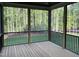 Inviting screened-in porch with black railings and a tranquil view of the lush, green surroundings at 3913 Cedar Knolls # 7, Youngsville, NC 27596