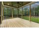 Covered back porch with wood flooring, black railings, and peaceful wooded views at 3913 Cedar Knolls # 7, Youngsville, NC 27596